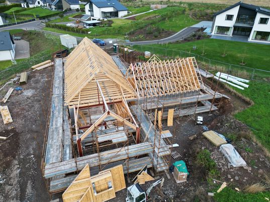 Drone shot of house under construction with roof trusses